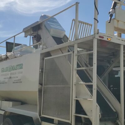 Industrial straw blower machine on a sunny day.