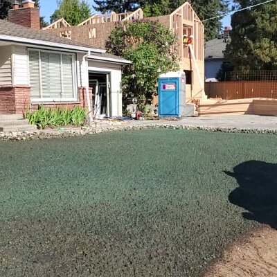 Freshly hydroseeded lawn with house and construction in background.