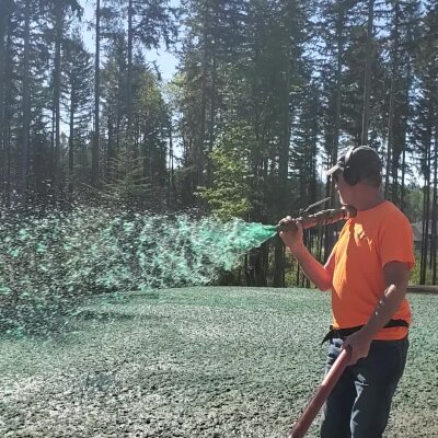 Man applying hydroseed mixture to lawn in Washington state.