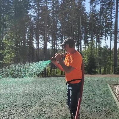 Hydroseed technician applying mixture to lawn in Washington state.