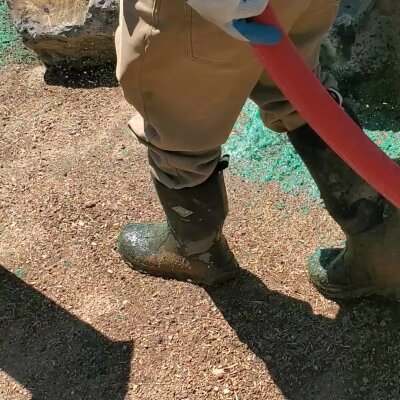 Hydroseeding technician applying mulch and seed mixture in Washington.