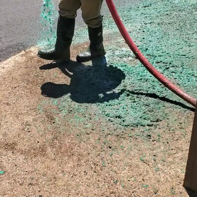 Worker applying hydroseed mixture on lawn in Washington State.