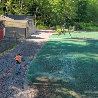 Worker applying hydroseed mixture on lawn in Washington State.