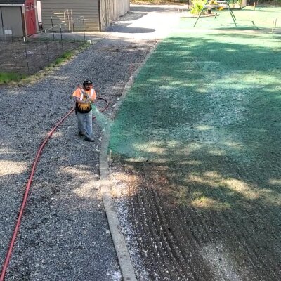 Worker applying hydroseed mix to lawn in Washington state.