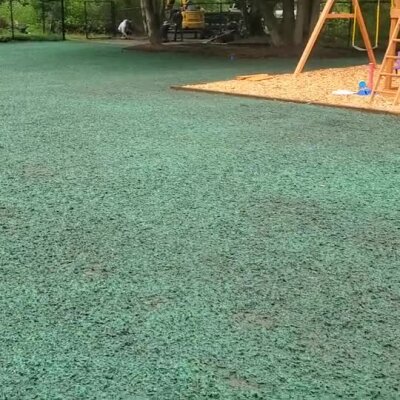 Fresh hydroseed applied on playground area near wood chips and trees in Washington.