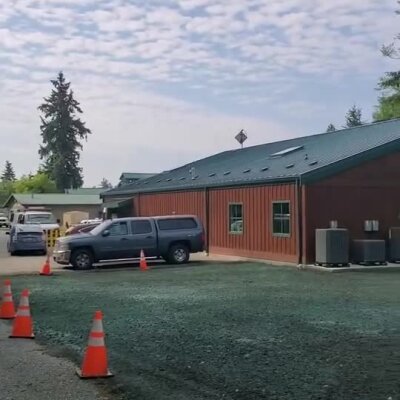 Freshly applied green erosion control mulch around commercial building parking lot.