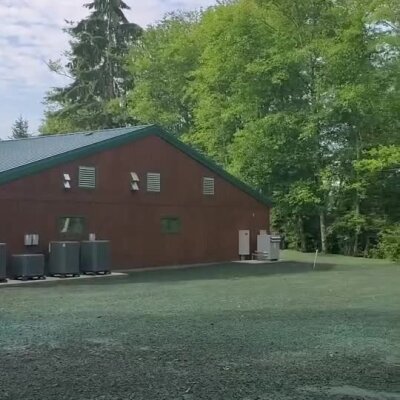 Freshly applied erosion control spray around commercial building with surrounding trees.