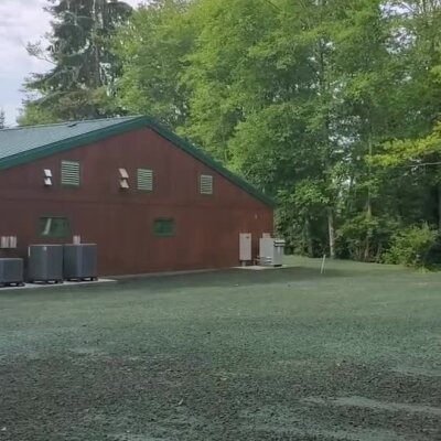Freshly sprayed erosion control mulch around animal shelter building in wooded area.