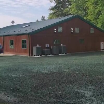 Newly installed erosion control spray on soil around animal shelter building.