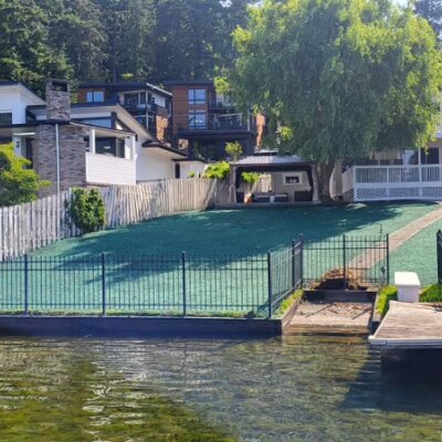 Waterfront residential lawn in Kirkland with fresh green hydroseeded grass near dock and fence.