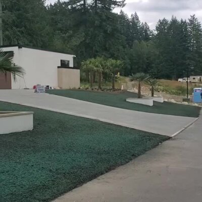 Fresh hydroseed lawn applied on a new construction front yard with modern landscaping.