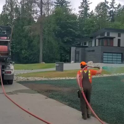 Worker spraying hydroseed on front yard of new construction home in Redmond.