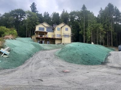 New custom home site with hydroseeded lawns and erosion control on slopes.