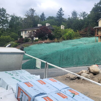 Hydroseed application on large sloped yard near newly constructed home.