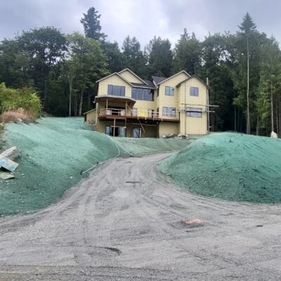 New custom home site with hydroseeded lawns and erosion control on slopes.